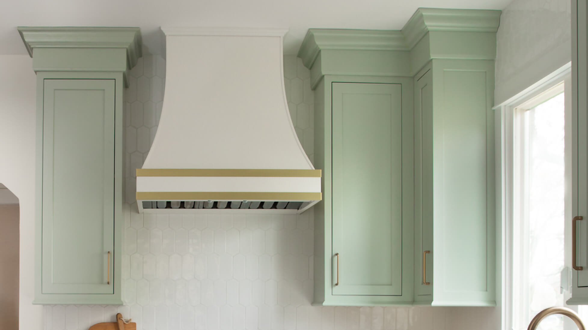 Why would you void a corner with kitchen cabinets? A wall cabinet corner with a voided corner in minty green painted finish and inset cabinet doors.