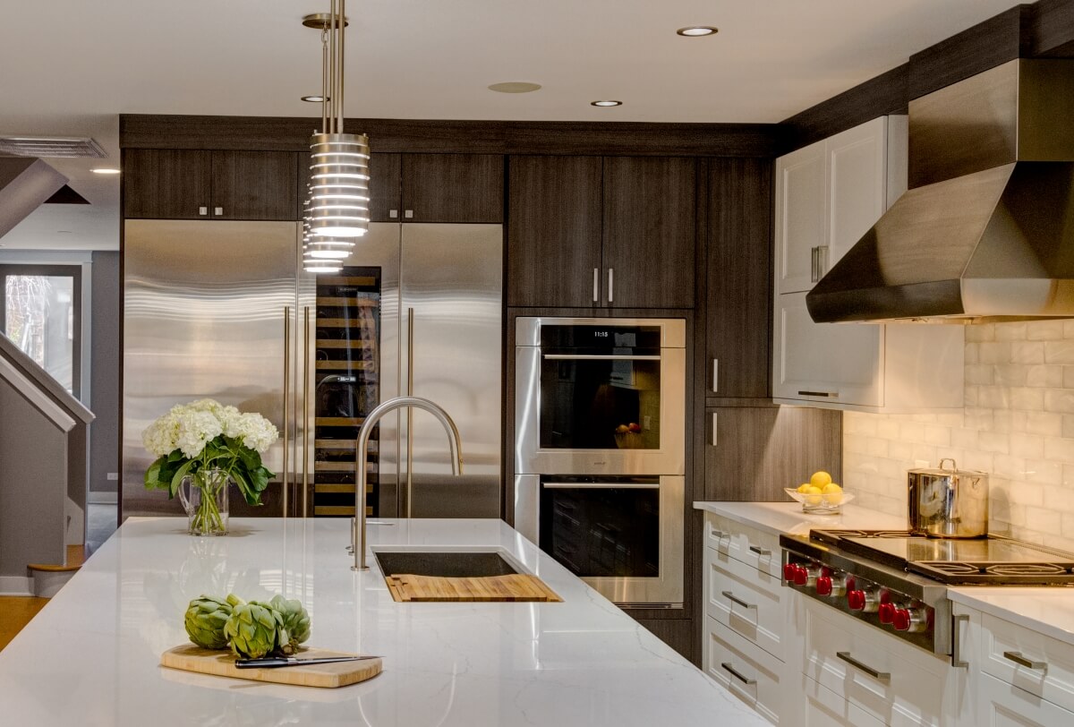 A stunning two-toned modern kitchen that combines white painted shaker cabinets with modern, textured laminate cabinets.