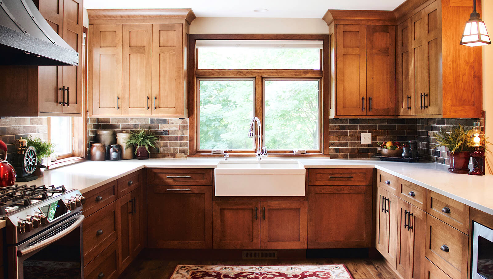 A luxury craftsman style kitchen design with an apron sink window view and oak cabinets.