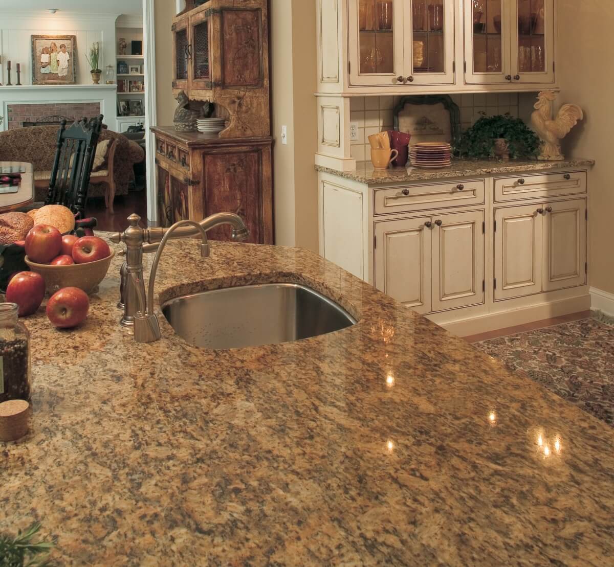 A traditional farmhouse kitchen design with white cabinets and gray stained wood featuring coordinating white granite countertops.