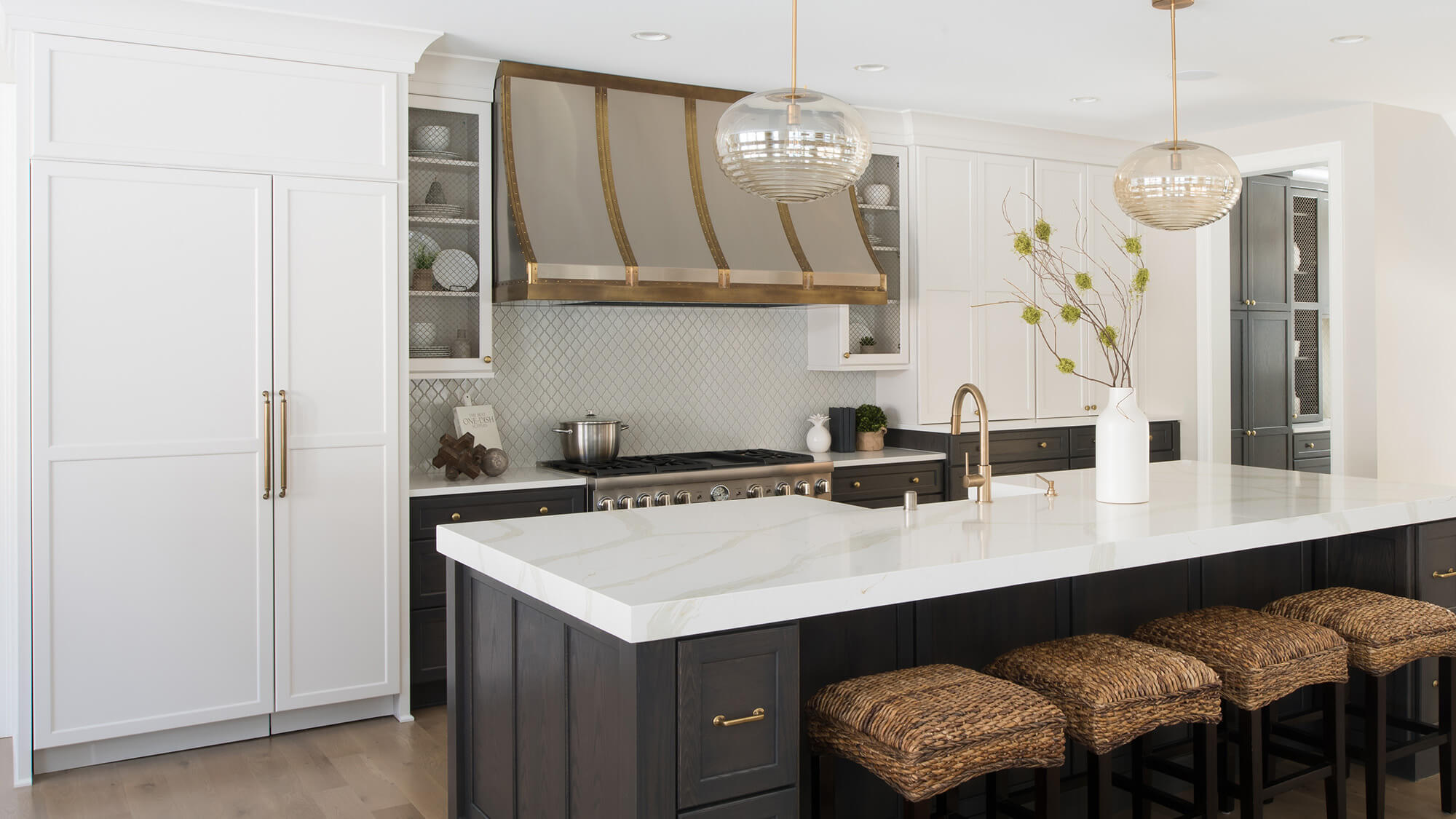 A large refrigerator is hidden with shaker style cabinet doors that match the rest of the kitchen design.