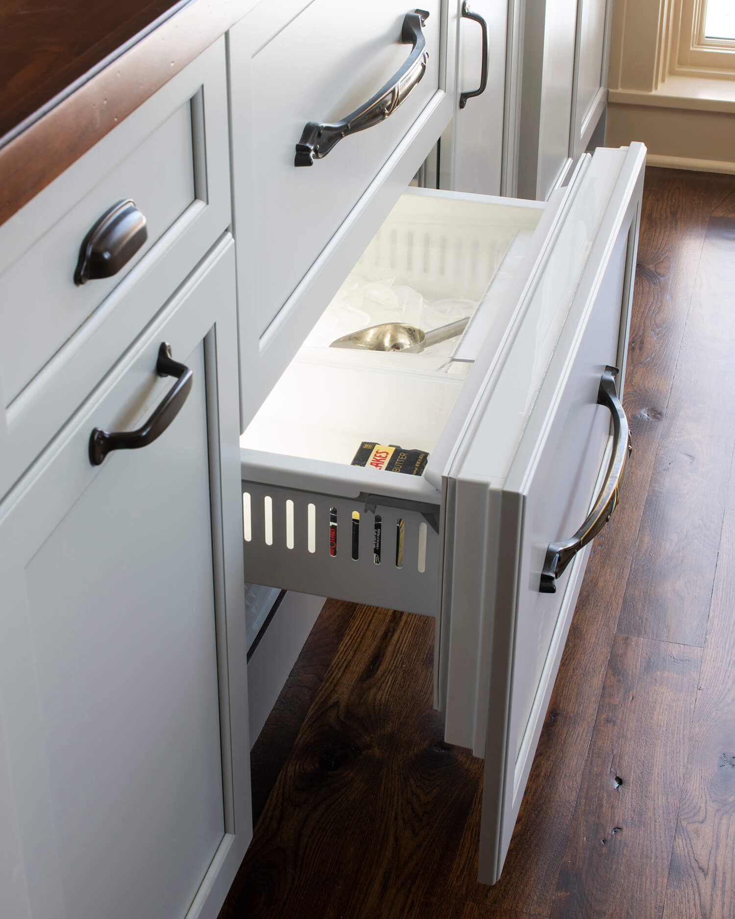 A hidden icemaker drawer with an appliance panel front.