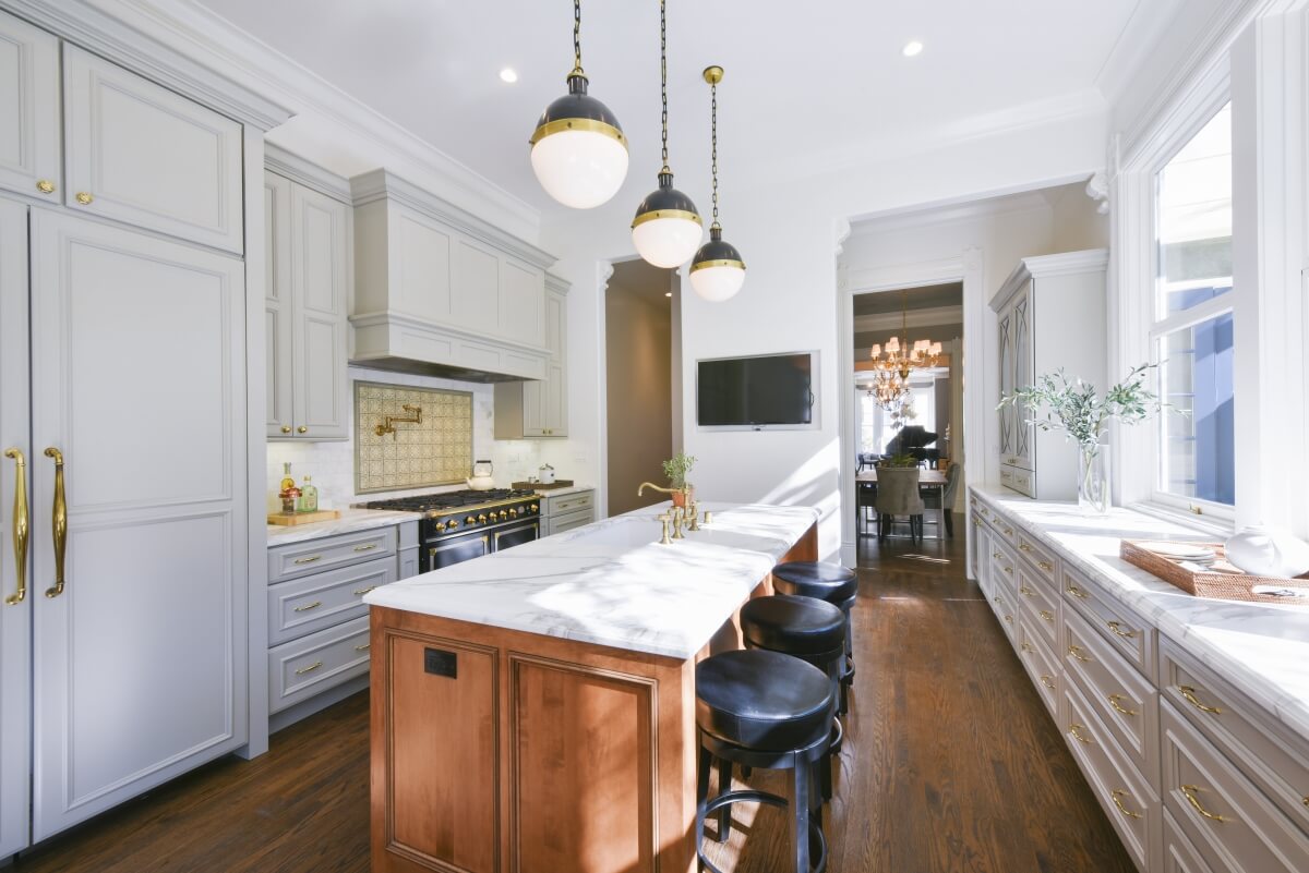 Counter height bar stool seating at a kitchen island with a kitchen island sink.