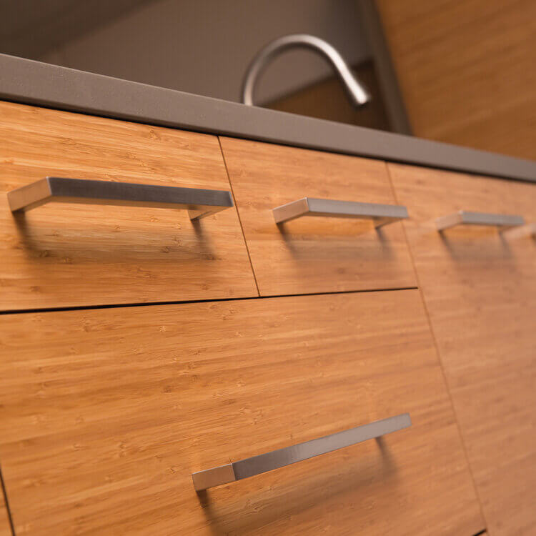 A close up of Bamboo exotic veneer cabinets with a slab door style,