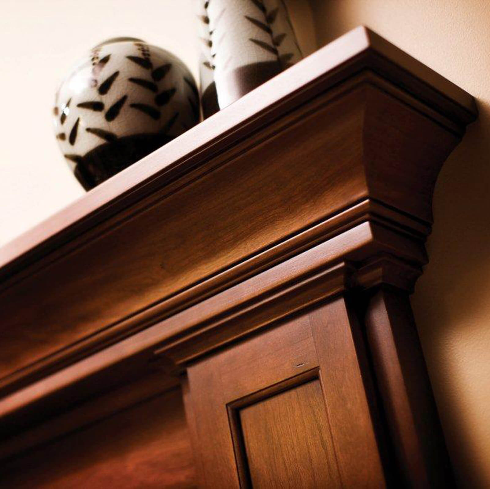 A close up of a custom cherry wood fireplace mantel shelf by Dura Supreme Cabinetry.