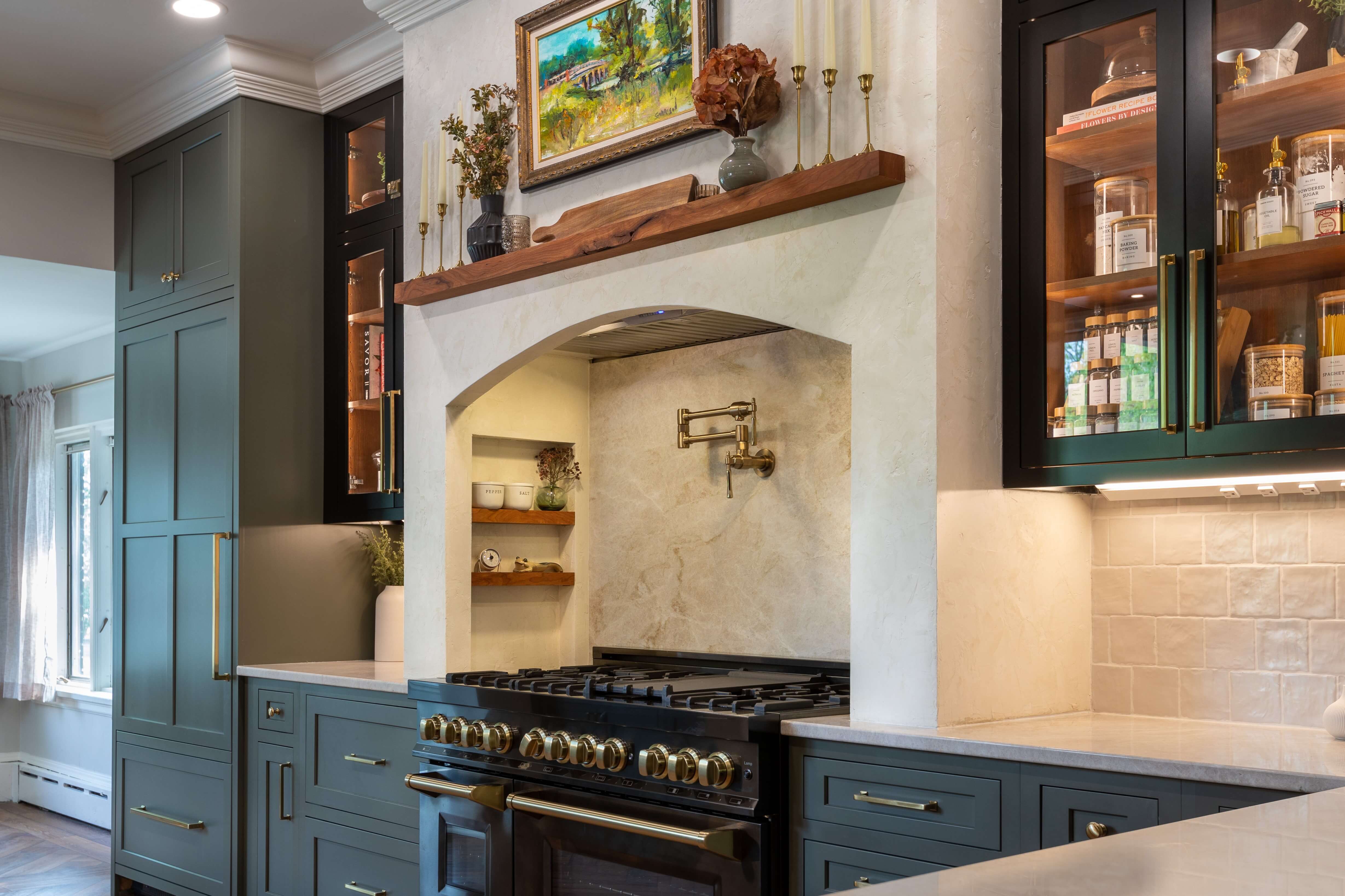 The range alcove design has arched drywall/plaster frame around with a floating mantel shelf above and small spice rack shelves on the side walls of the alcove.