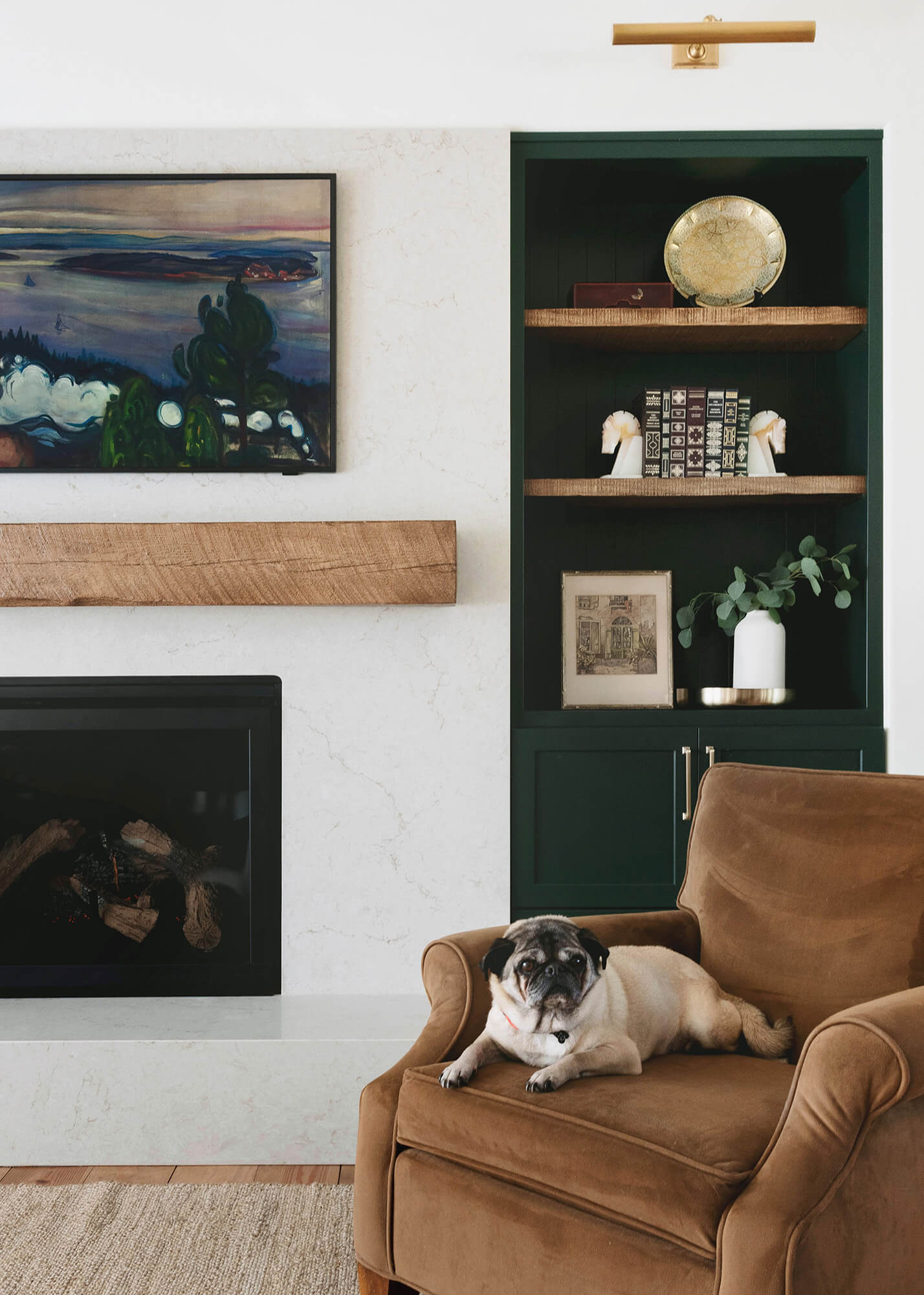 A luxury living room design with a fireplace wall with dark green painted built-in cabinets and bookcases from Dura Supreme Cabinetry.