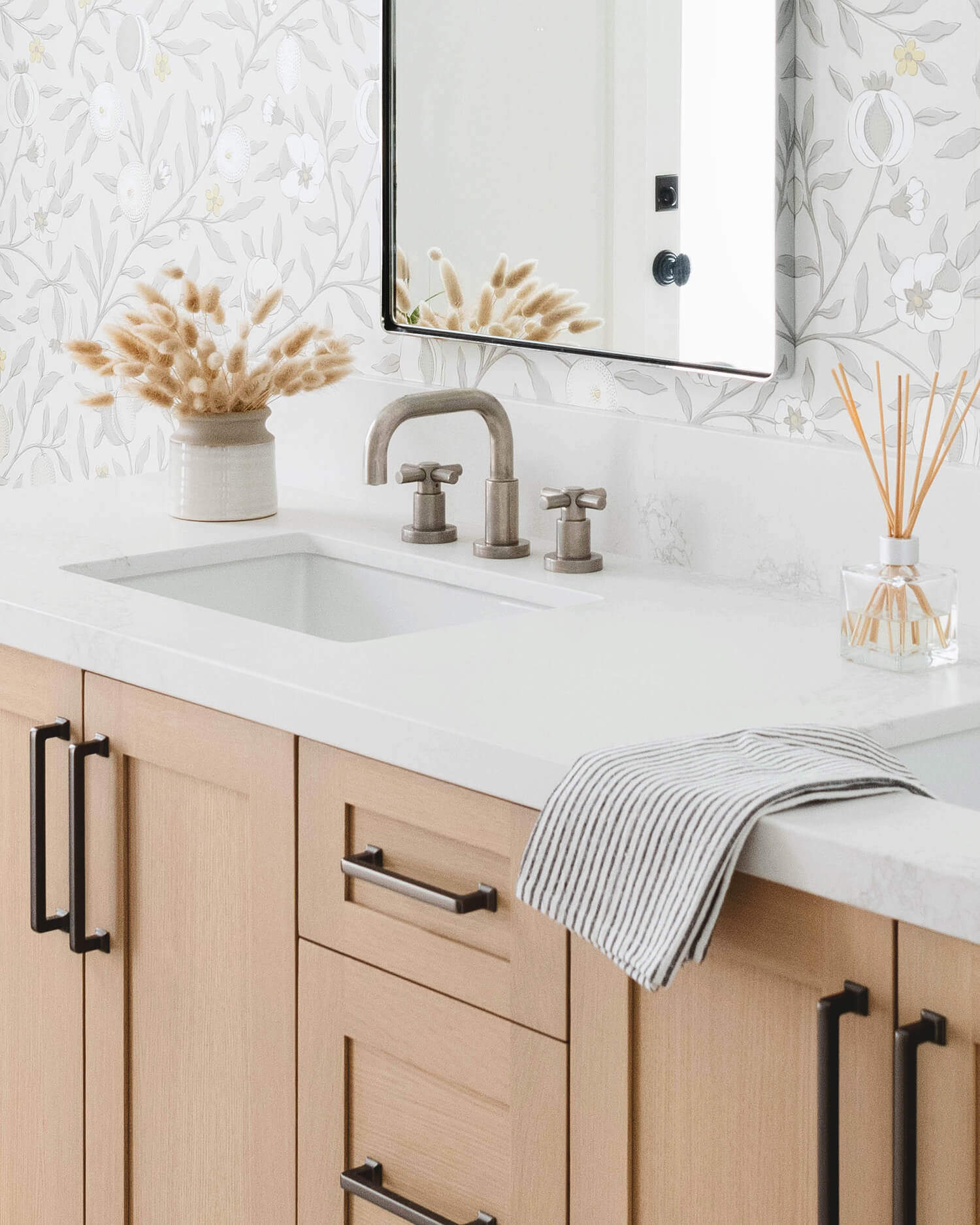 A stunning bright bathroom design with light stained rift cut white oak cabinets.