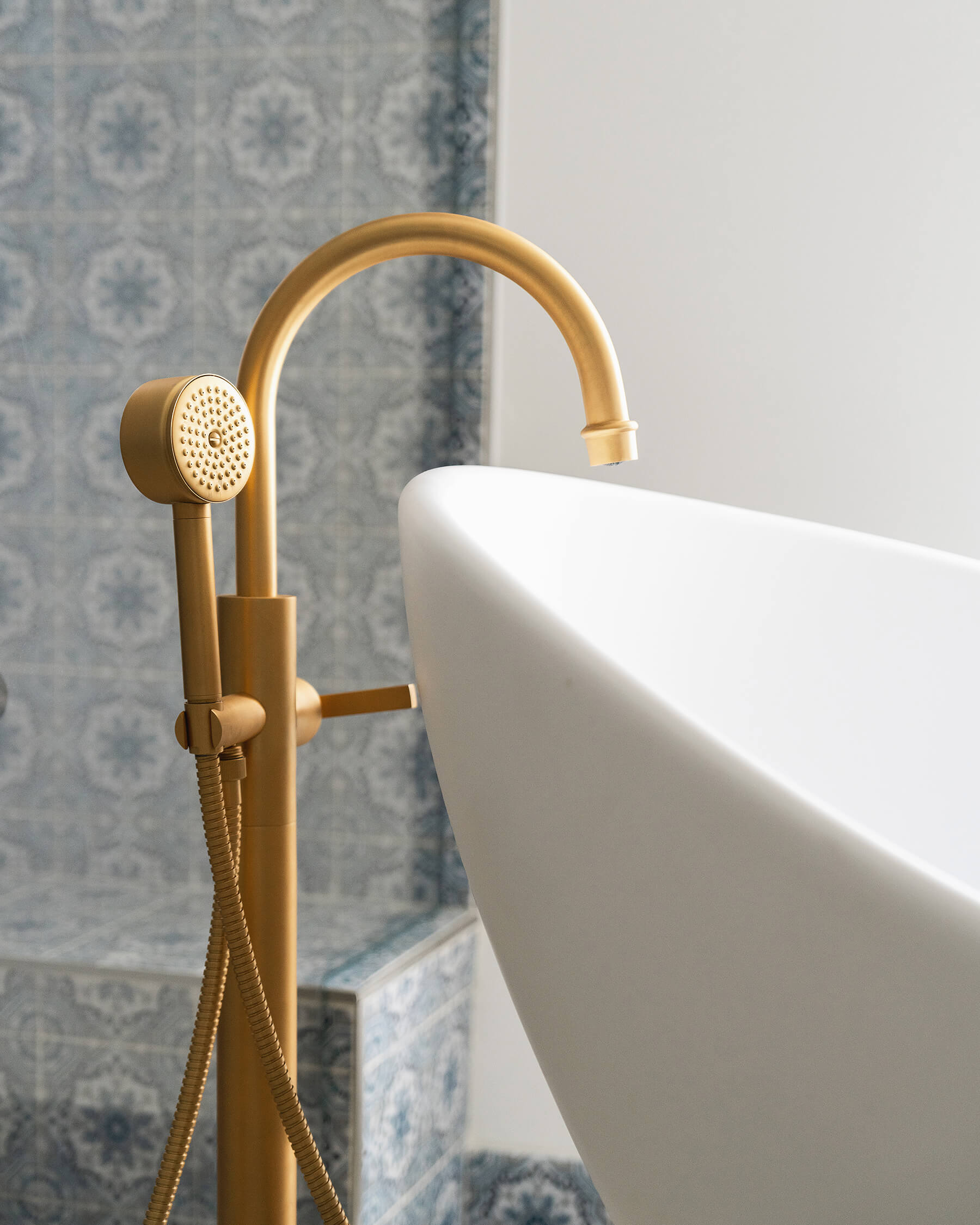 A close up of luxury brass bath tub faucet and hardware in a high-end bathroom design.