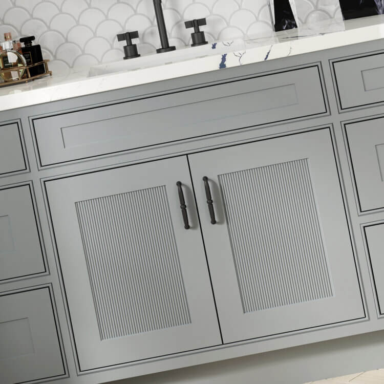A close up of a bathroom vanity with Reeded cabinet door inserts used as accents to add texture to the design.