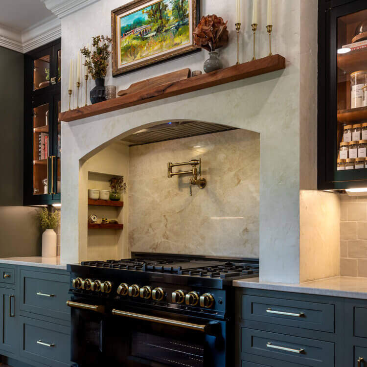 A traditional styled range alcove kitchen with dark green painted cabinets from Dura Supreme.