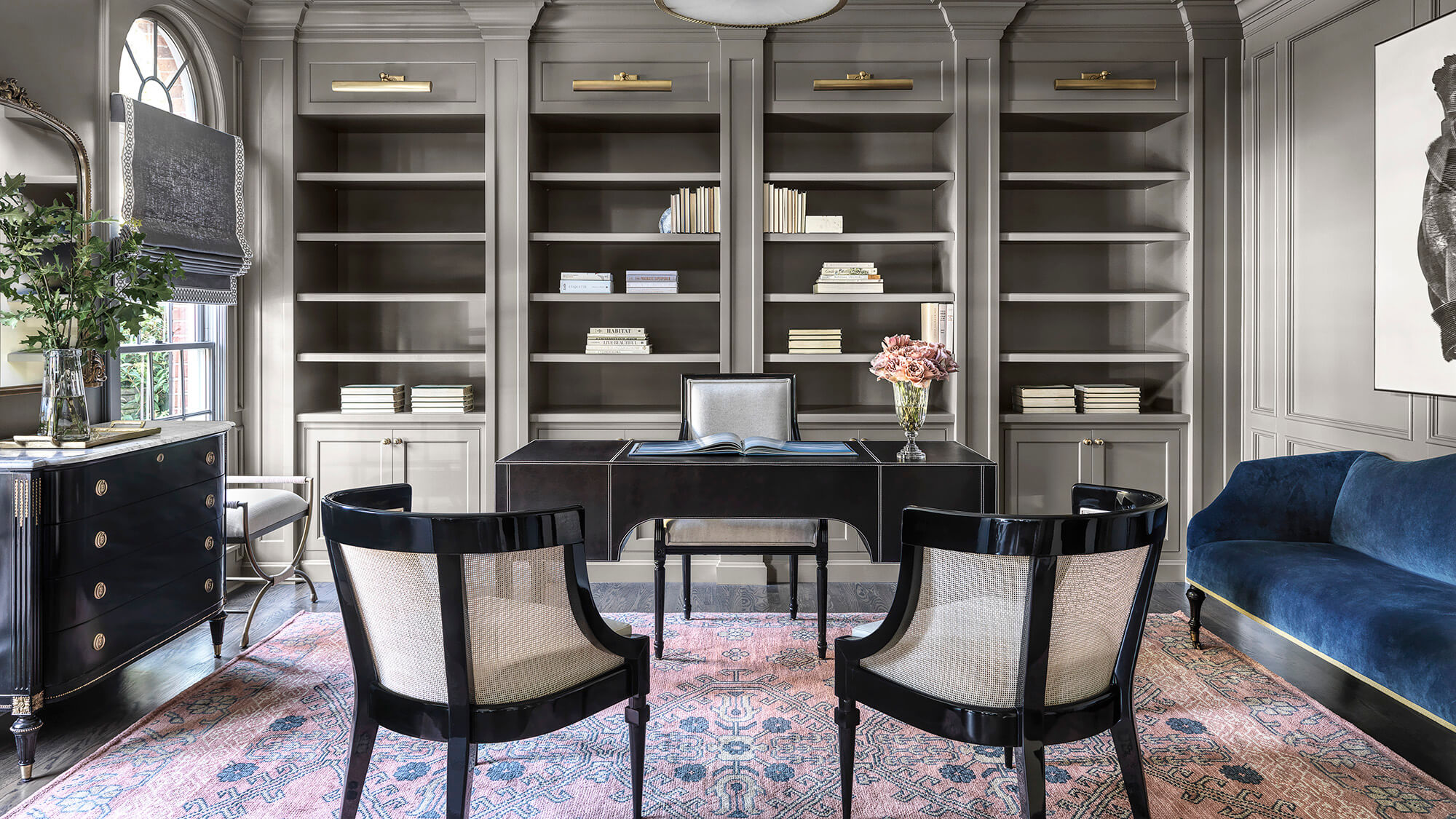 A home office that is color drenched in gray finishes and with small accents of blue and pale pinks.