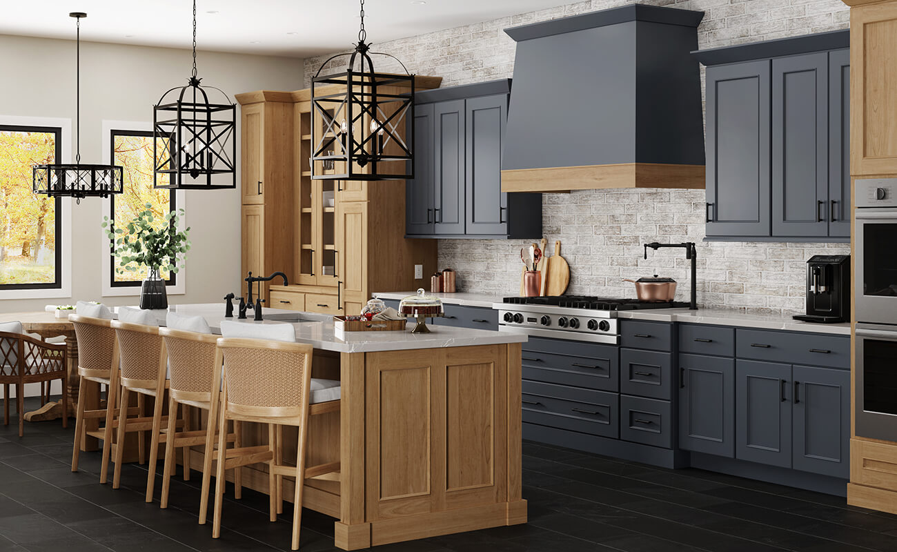 A stunning remodeled kitchen design with an English style and modern finishes showing a dark navy blue painted cabinets with medium stained cherry cabinets.