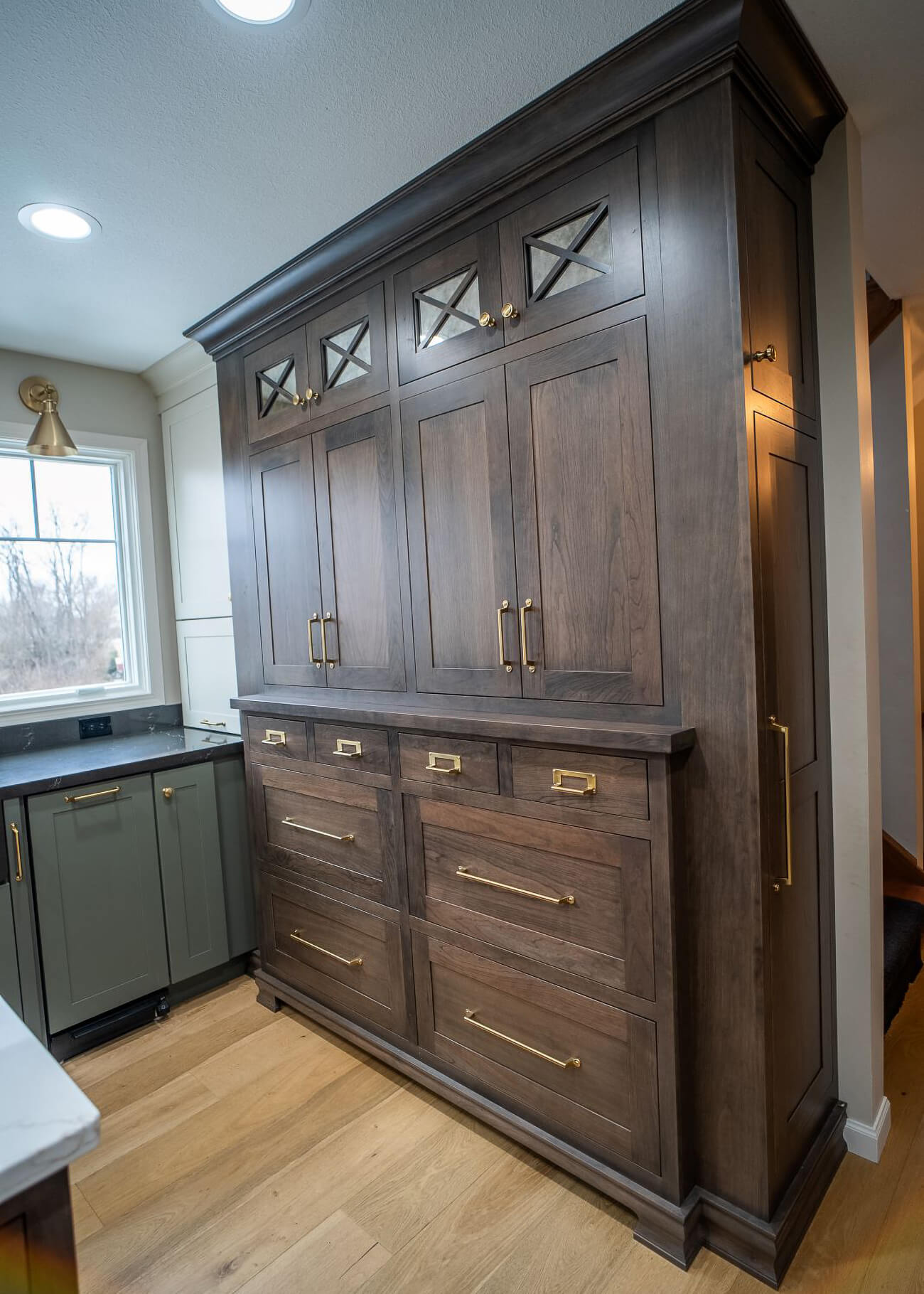 This area of floor to ceiling cabinets was designed to look like a custom hutch to give the space an elegant, historic look.