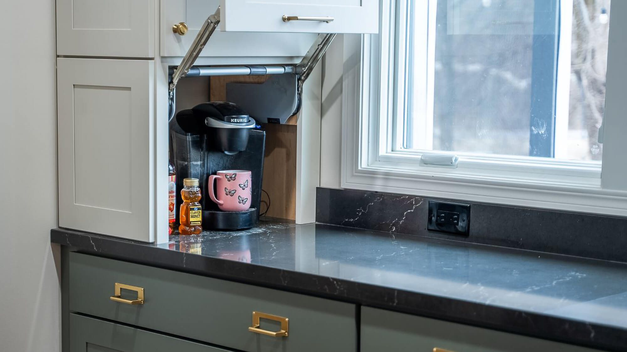 A coffee station is hidden at counter height with a lift-up door for easier access.