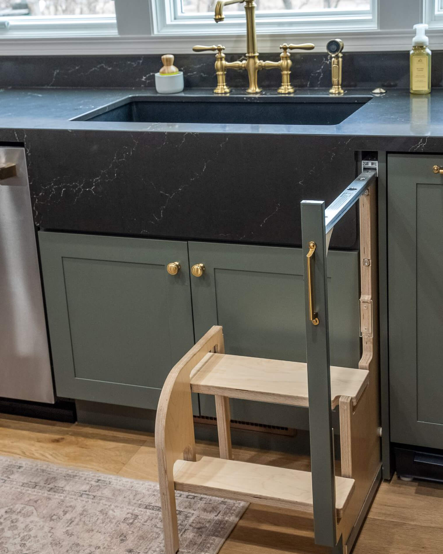 A pull-out stool is also by the kitchen sink to make it easy for children of the home to help out with dishes and other kitchen tasks.