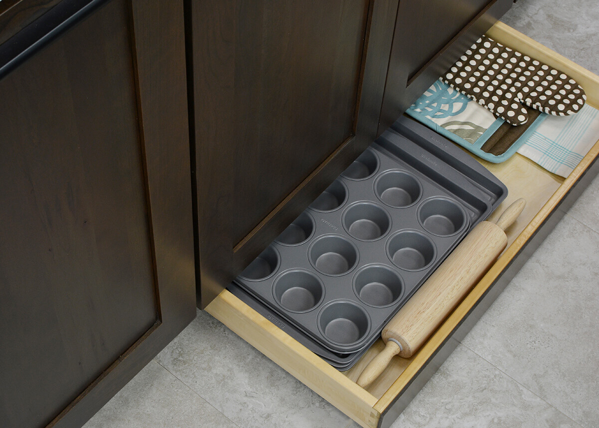 Miscellaneous items can find a home in a Dura Supreme Toe Space Drawer hidden at the foot of your cabinets. This convenient solution adds additional storage to any room. It’s great for bakeware, spare oven mitts, rolling pins, cutting boards, and so much more!